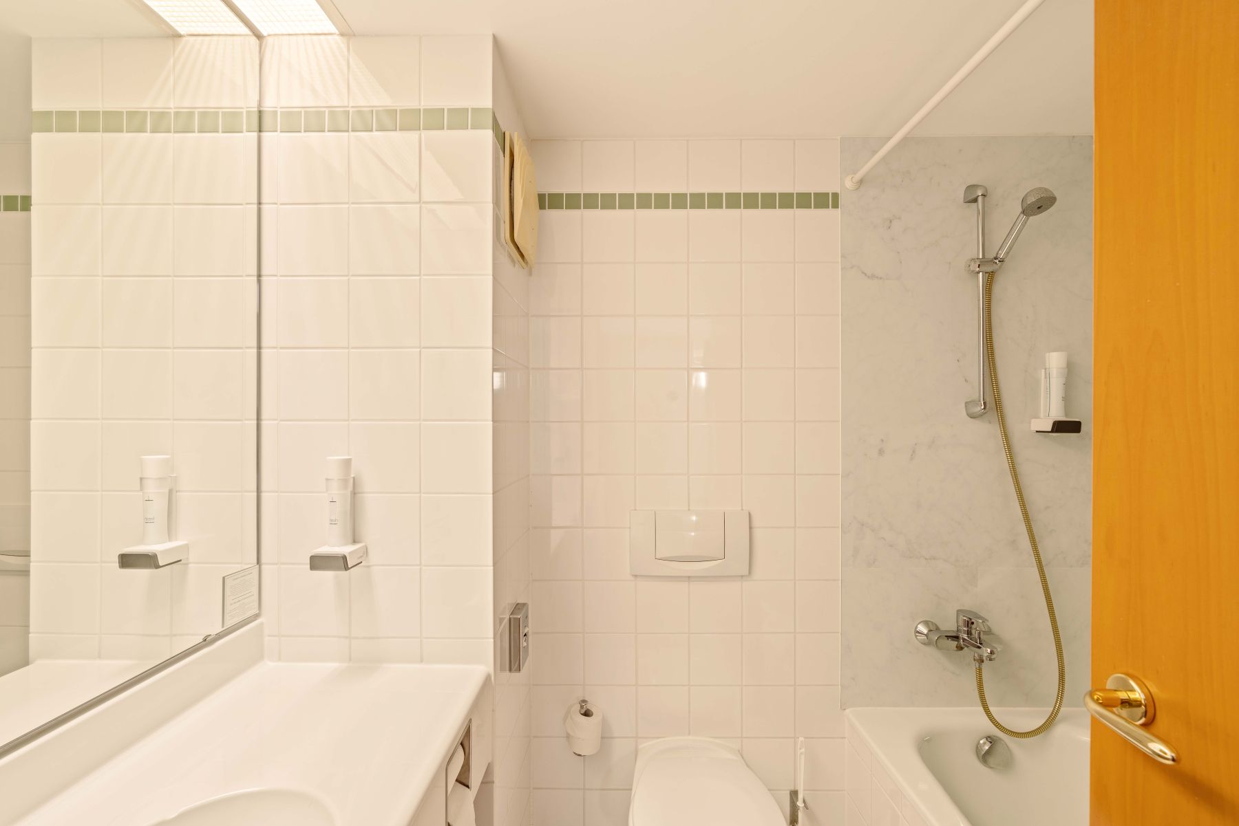 Modernes Badezimmer im Familienzimmer mit Dusche, WC und hellen Fliesen